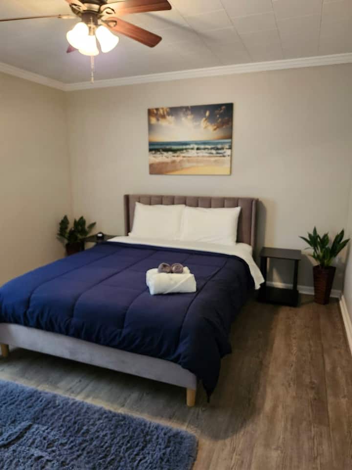 Chumba cha kulala chenye nafasi kubwa na kitanda cha malkia, kabati na rafu ya mizigo. 