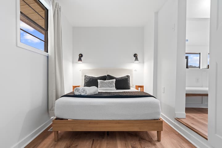 Justo al lado de la sala de estar, el dormitorio queen con TV