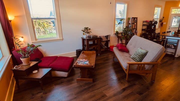 พื้นที่อเนกประสงค์ "ห้องนั่งเล่น" ภาพถ่ายส่วนที่ 1 - ฟูกควีนไซส์เหมือนใหม่แสดงอยู่ทางขวา เครื่องเล่นแผ่นเสียงและแผ่นเสียงอยู่ตรงกลาง พัดลมเพดาน