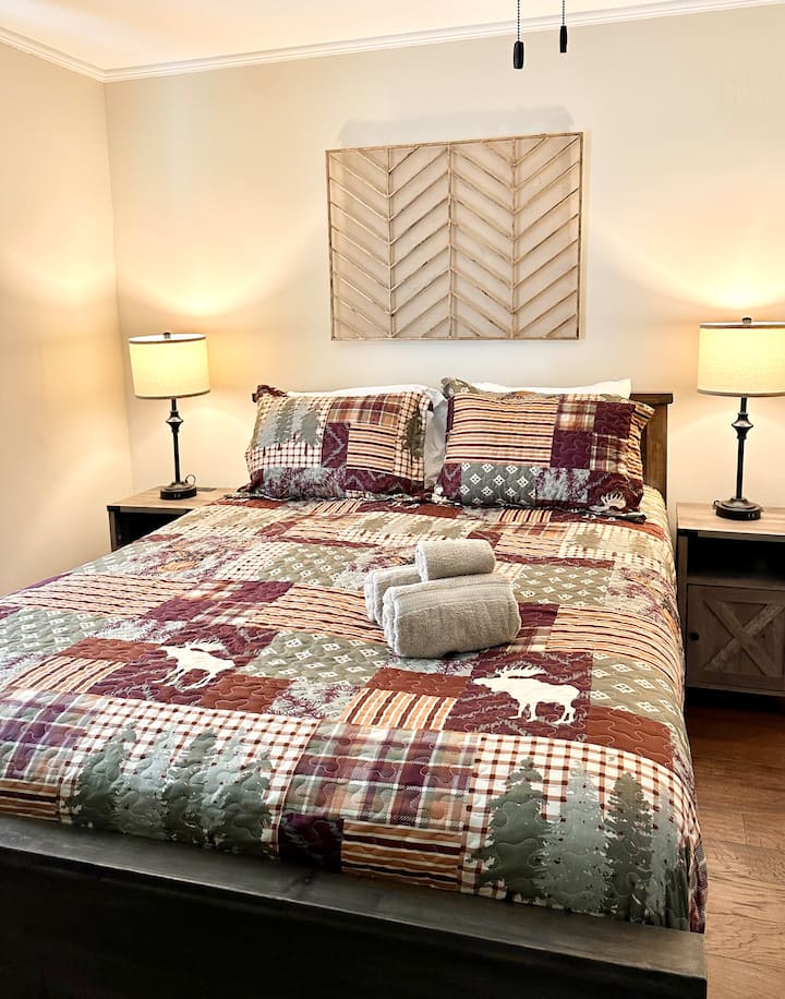 Un lit queen size, des draps confortables, des ports de recharge au chevet et une télévision connectée complètent cette chambre principale à thème rustique. Situé à l'extérieur du salon à côté de la salle de bain complète.