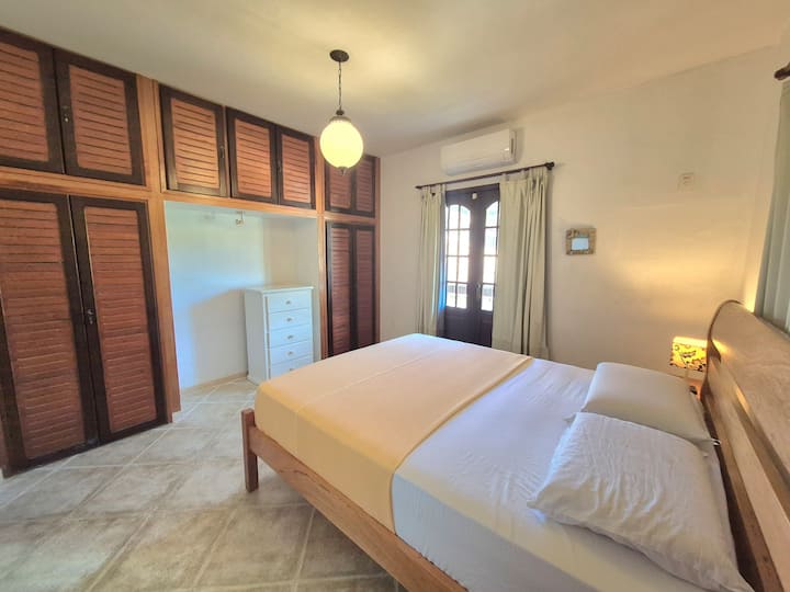 Master Suite yenye kitanda cha Queensize, godoro la majira ya kuchipua lenye mifuko, wahudumu 2 wa bubu, kinara cha taa, droo na makabati.