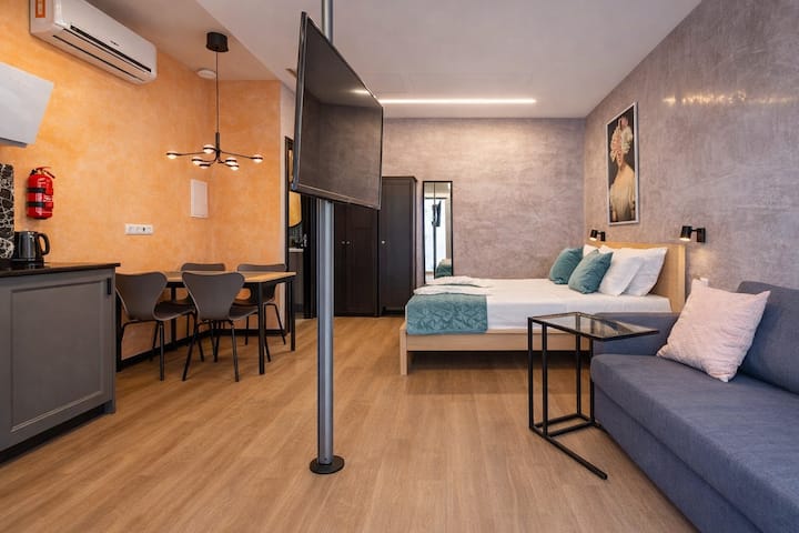 มุมมองแบบกว้างของห้องสตูดิโอ ทางด้านซ้าย เราจะเห็นห้องครัวเต็มรูปแบบและทีวีแบบหมุน ซึ่งมองเห็นได้จากเตียง โซฟา หรือห้องครัว จึงใช้พื้นที่ได้อย่างมีประสิทธิภาพสูงสุด