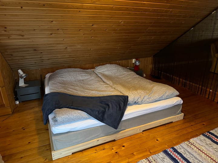 أنت تنام بشكل مريح في السرير المزدوج تحت السقف المائل في الطابق العلوي.