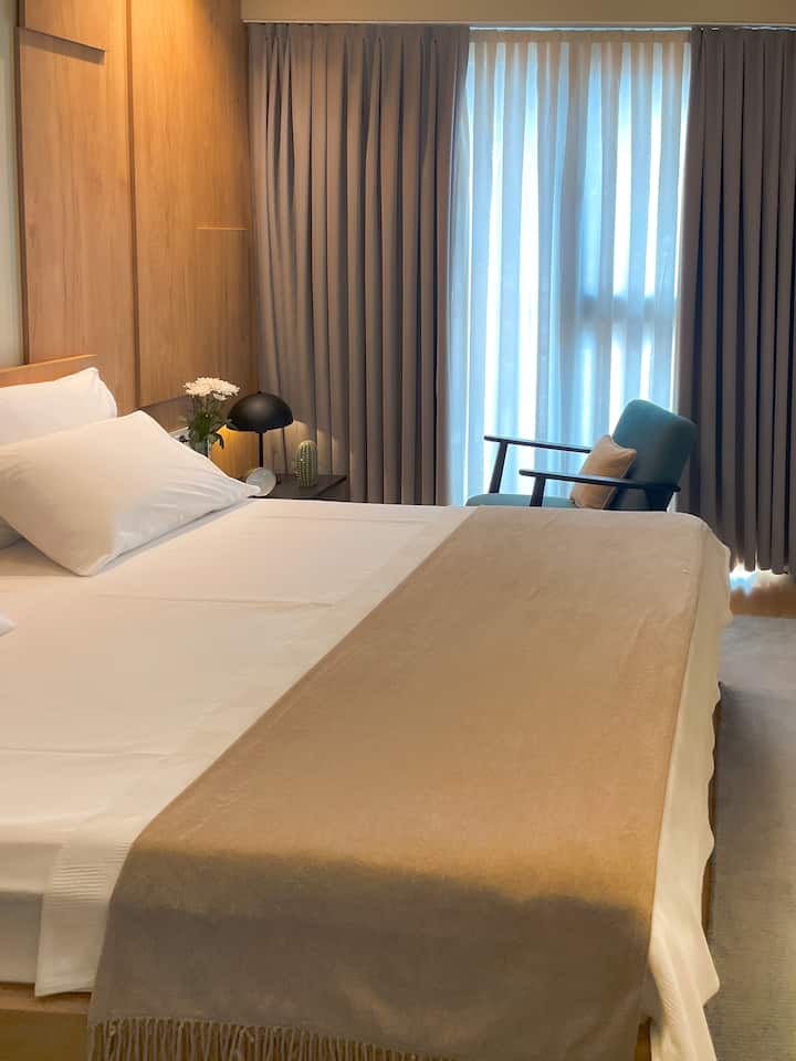 Спокојна спална соба со врвен квалитет на постелнината, слоевит текстил и мека природна светлина. Дизајнирано да обезбеди исклучителна удобност и мирна средина за длабок, обновителен сон.