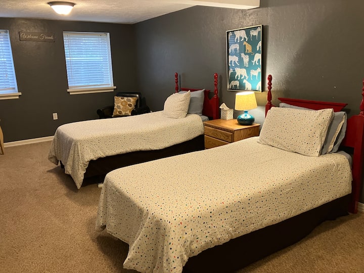 سريران متماثلان في غرفة نوم كبيرة في الطابق السفلي.