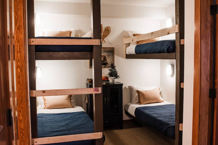 Detta anpassade våningsrum rymmer bekvämt 4 vuxna eller barn. Detta mysiga utrymme är perfekt för grupper eller familjer. Varje våningssäng har sitt eget personliga ljus och utrymme för tillhörigheter. Med bekväma våningssängar i två storlekar och en byrå. 