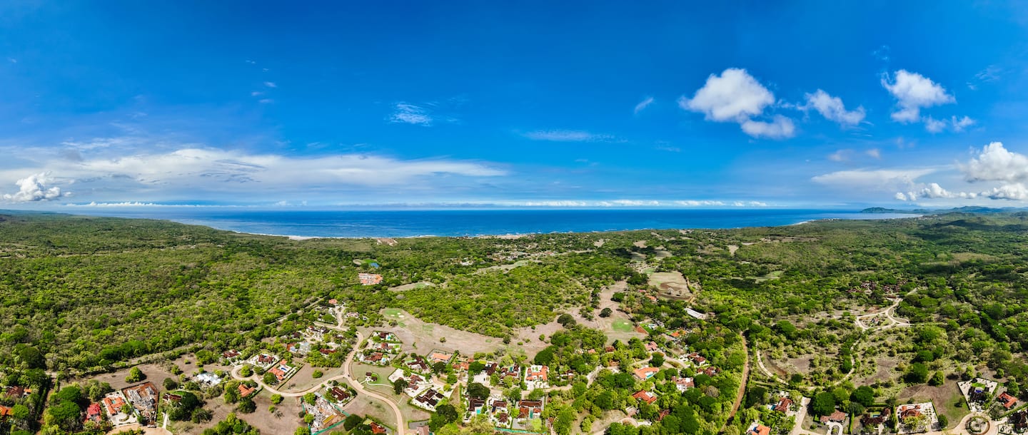 Aerial view over Hacienda Pinilla's forest to the Pacific