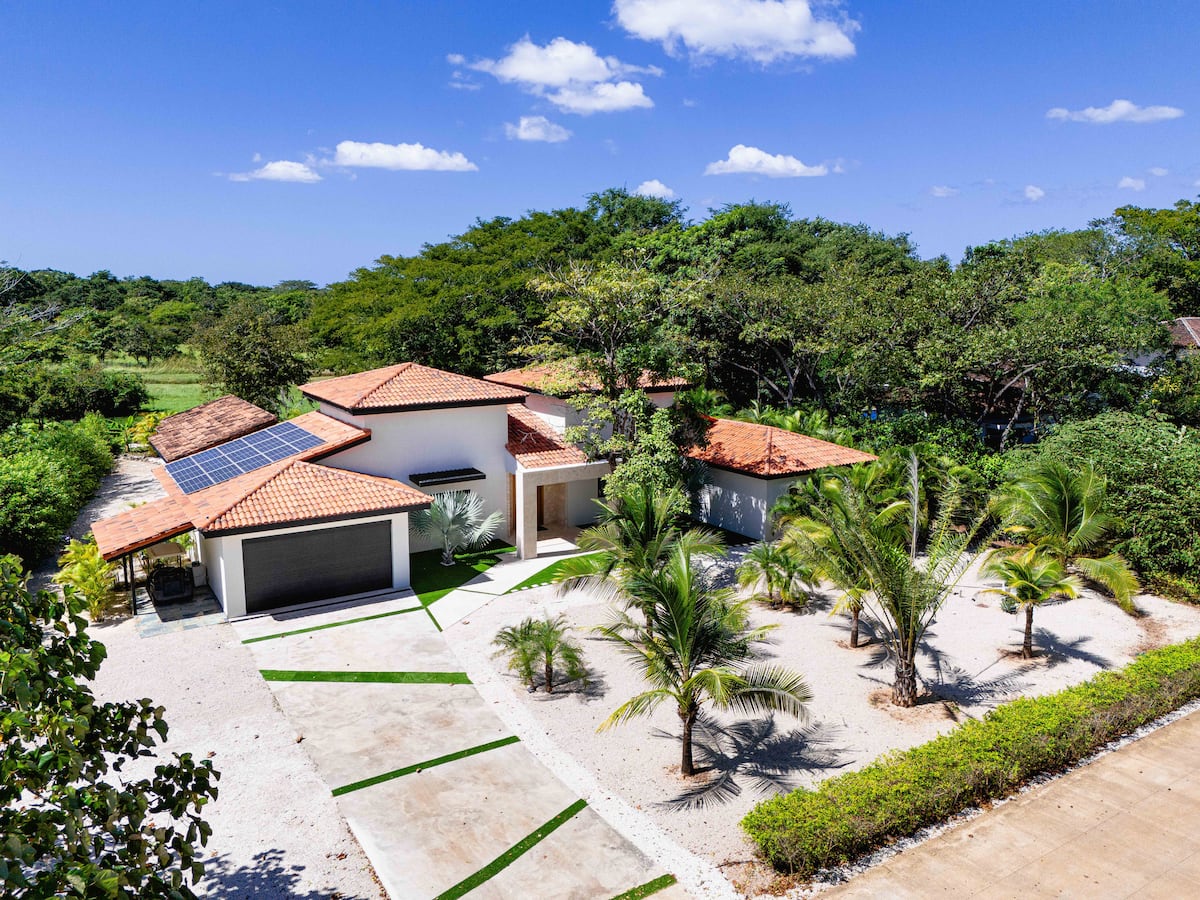Villa NAUA from above in morning light, green hills behind