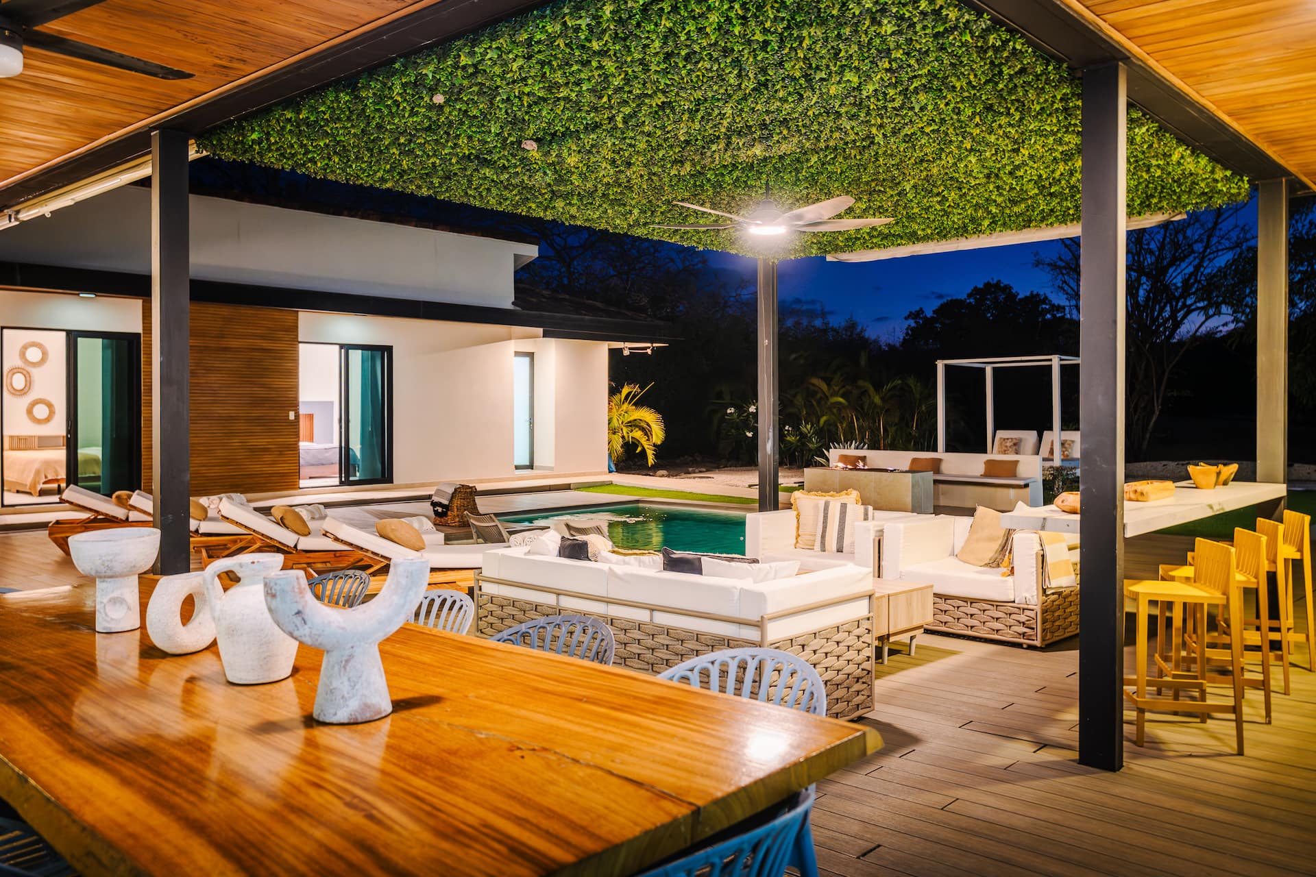The long wooden table on Villa NAUA’s covered terrace at night