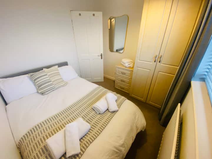 Super cosy bedroom with a small double bed and matching wardrobe and chest of drawers.