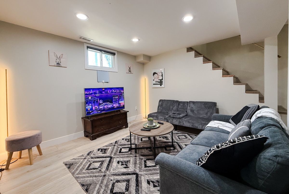مسرح صغير في الطابق السفلي مع تلفزيون 55 بوصة عالي الدقة مع Roku لبث جميع تطبيقاتك وأريكتين مريحتين. 