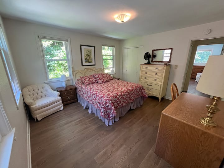 Hovedsoveværelset har en queensize-dobbeltseng, natborde, dedikeret arbejdsplads, kommode, en flot stol, plads i skabet og badeværelse en suite med en skydedør, der kan lukkes.