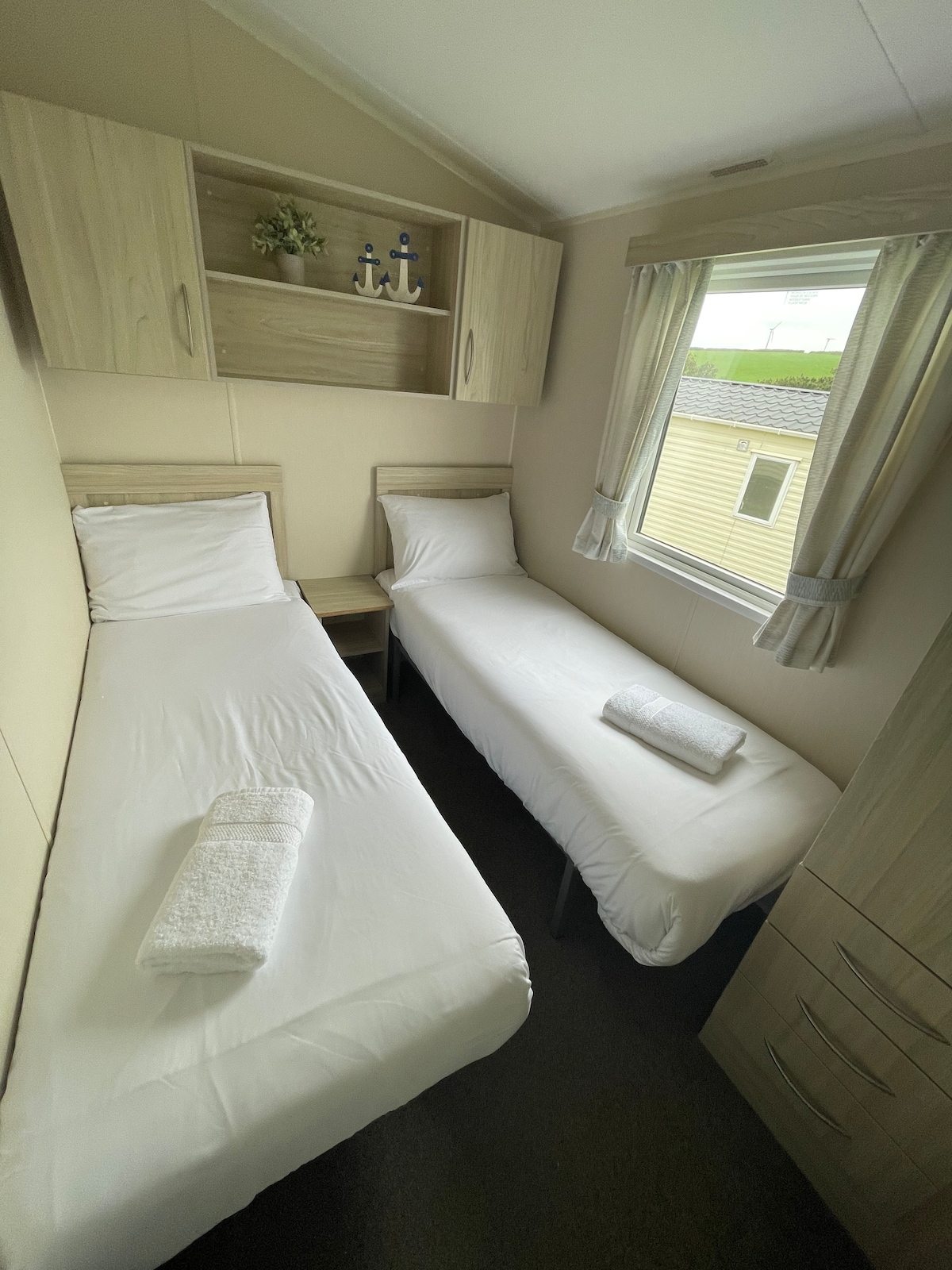 Twin room consisting of overhead storage, wardrobe and central heating.