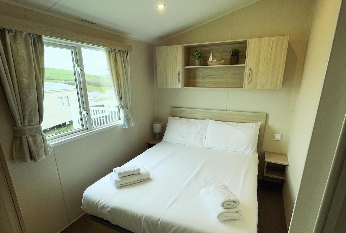 Master bedroom consisting of a double bed with under bed storage, overhead storage, wardrobe/draws, vanity mirror and central heating. Hairdryer is stored in the drawer.