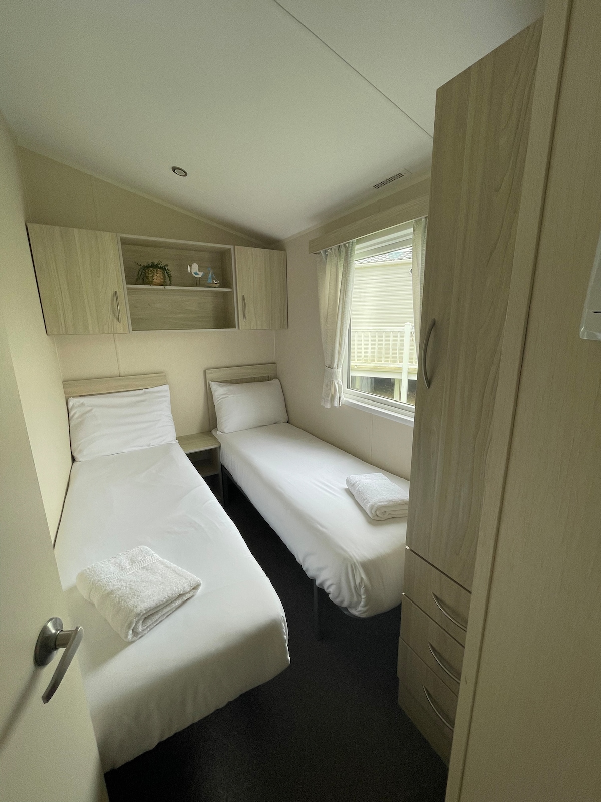 Seconded twin room consisting of overhead storage, wardrobe and central heating.