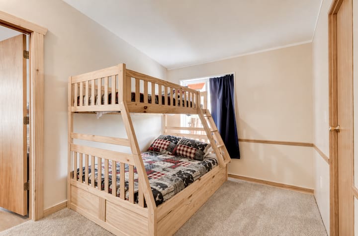This cozy bunk room is perfect for kids or groups, featuring a twin-over-full log bunk bed and soft bedding with a cabin theme. Bright and spacious with plenty of room to relax, it’s ideal for family stays or mountain adventures with friends.