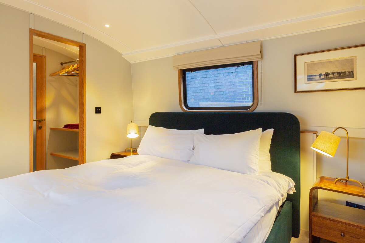 غرفة نوم رئيسية بسرير بمقاس كبير مع لوح رأس مخملي فاخر. توصيل الباب بالحمام، من خلال منطقة غرفة الملابس مع رفوف واسعة ومساحة معلقة 