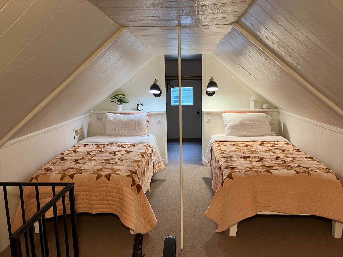 Twee Twin XL bedden zijn beschikbaar in de slaapkamer op zolder, toegankelijk via de kleine wenteltrap.