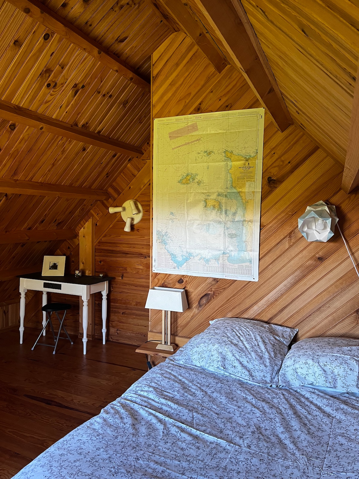 חדר שינה למעלה עם מיטה זוגית ונוף לגינה.