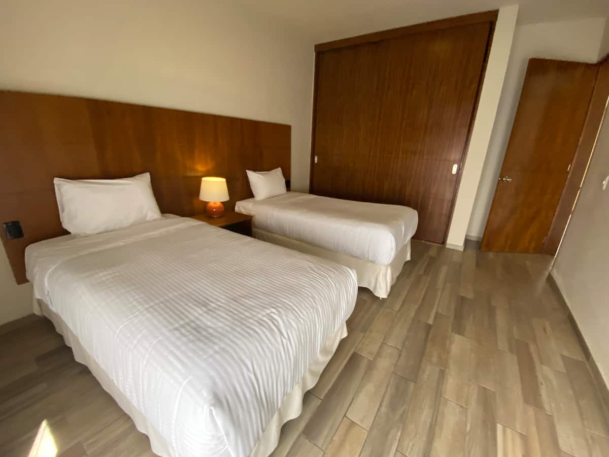 Detalle de sala de estar con sofá rojo y ventilador de techo - Villa La Ceiba