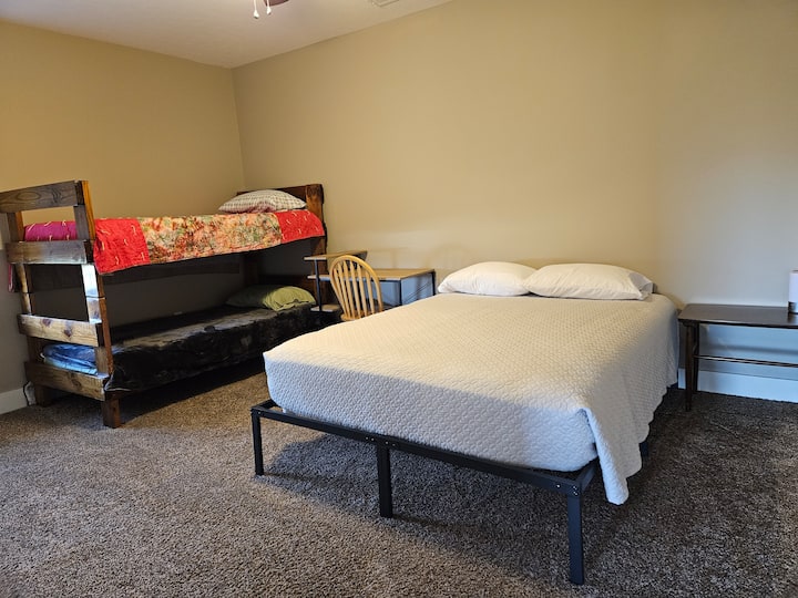 Tempat tidur queen dan tempat tidur susun, dengan meja.  Tidak jauh dari dapur.