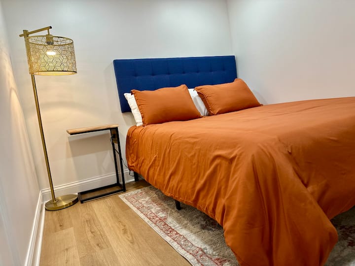 חדר שינה נעים עם ארון משלו, מיטת קווין סייז, מנורה, מראה ושידה הכוללת שקעים, כך שתוכלו לטעון כל אחד מהמכשירים האישיים שלכם.