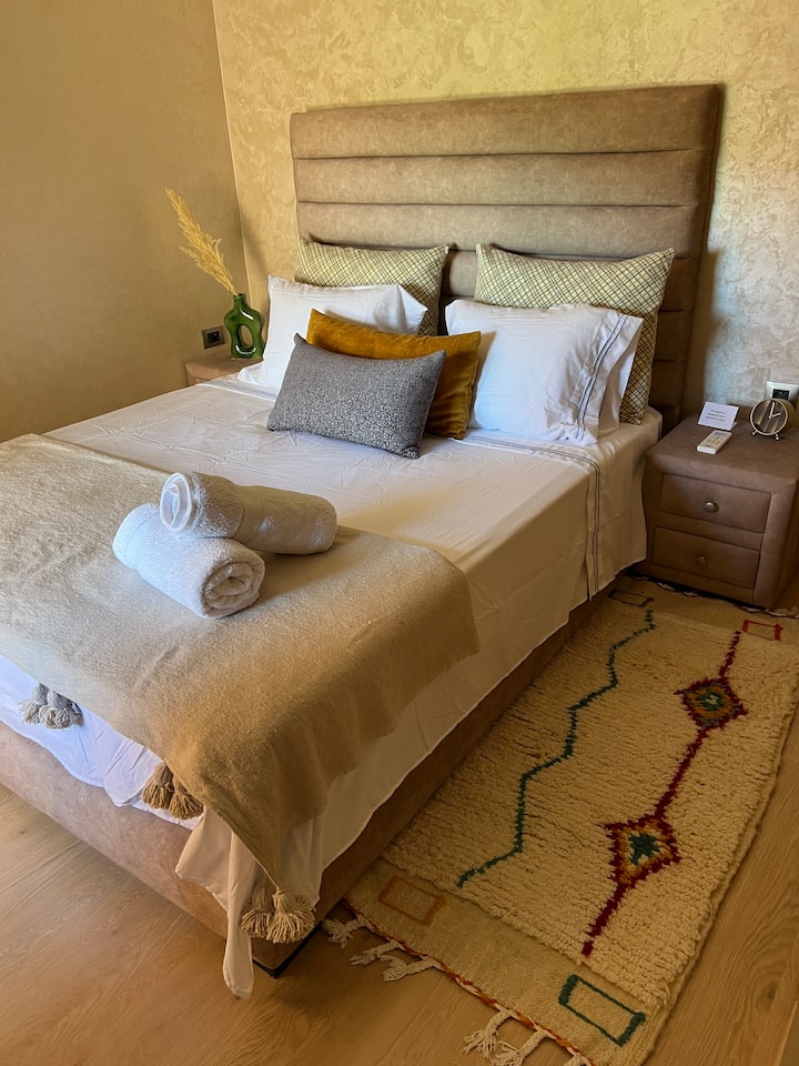 כריות מלאות למטה, מזרן קצף בגודל קווין סייז מאיטליה. מגן מזרן, סדיני כותנה רכים, שמיכה מטושטשת חמה וזריקה ברברית בעבודת יד. מתלה למזוודות. שטיח צמר ארוג ביד