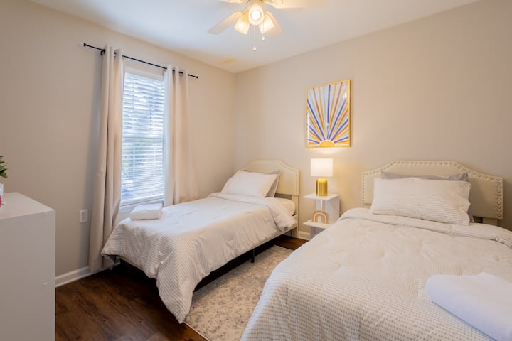 ห้องพักพร้อมเตียงแฝด 2 หลังโต๊ะข้างเตียงและที่จัดระเบียบลูกบาศก์ 