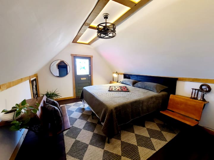 Upstairs luxury bedroom. Completely remodeled and new March of 2024! Features King size bed, antique school desks,  gorgeous romantic lighting, and a private deck. 