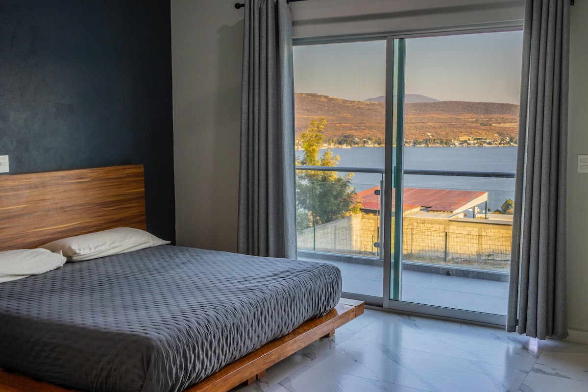 поглед кон езеро од чамара. спална соба со балкон од која може да го цените целото езеро 