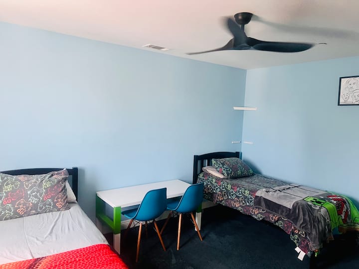 2 Twin-size beds, Flatscreen TV w/ Fire-stick, Black-out curtains, Bookshelf, Ceiling Fan, Dressers and Table w/ 2 chairs. Closet, Dressers and Bookshelf will be empty at check-in.