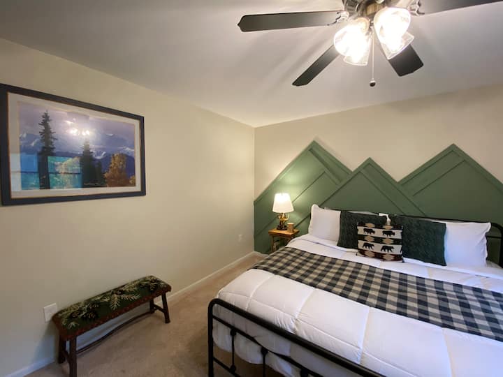 Krevat dopio "king size" me çarçafë të bardhë e të freskët. 
Një dhomë gjumi e madhe me banjë private brenda në suitë. Sfondi romantik malor i punuar me dorë nga EJ shton një dizajn unik në Whiteface Camp. 