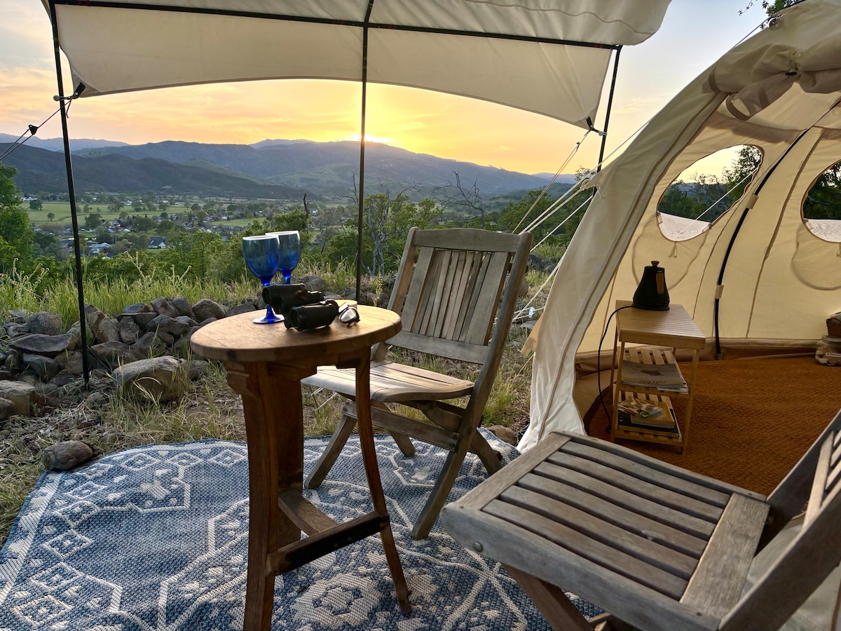 Sunset from your Private covered and shaded patio area for the Astral Lotus with teak chairs and wine barrel table, rug, and solar lights. at Stargazing Dome in Hidden Valley Lake