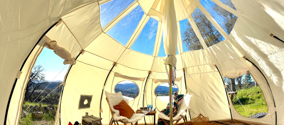 A panoramic view of the spacious living space, 4 meters wide, ten feet tall. Two bamboo canvas butterfly chairs with warm flotaki fur, real coconut coir carpet, oak wine barrel tab