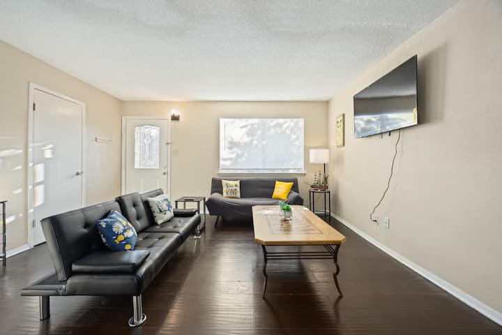 Salon confortable avec deux canapés-lits, une télévision intelligente et une lumière naturelle vive, parfait pour se détendre. 