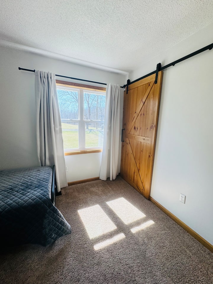 Verduisterende gordijnen in deze kamer en een kast met planken achter de schuurdeur