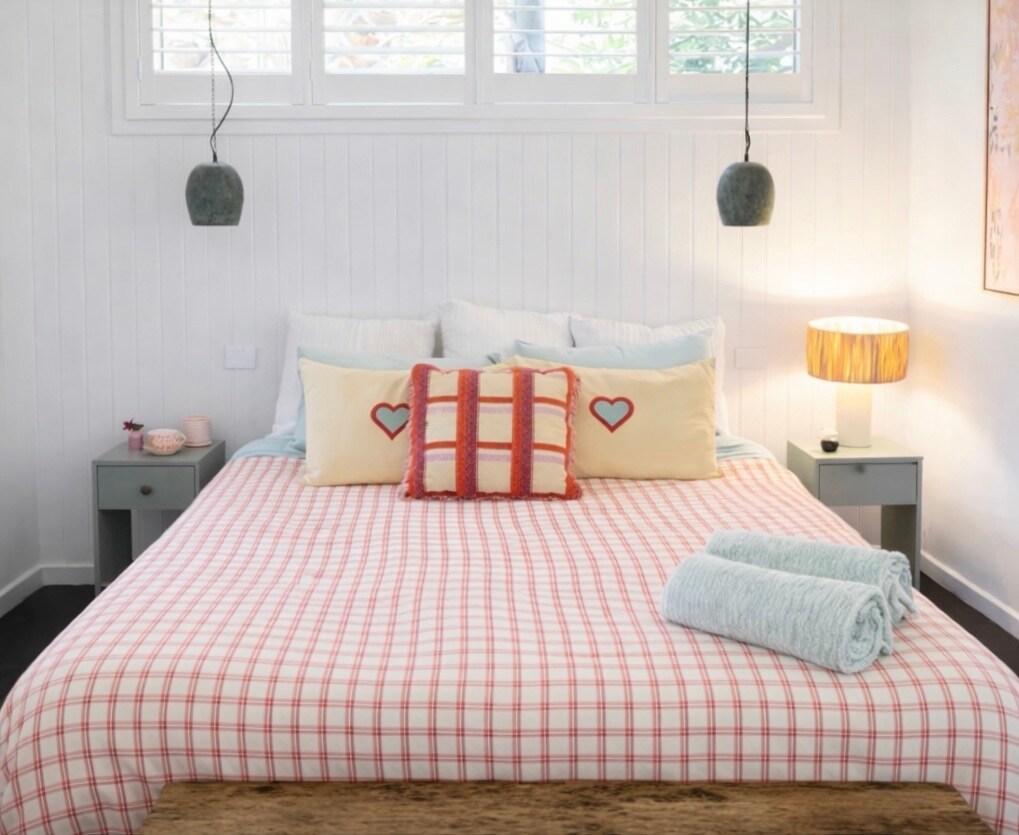 غرفة نوم مضاءة تتميز بمرتبة تمبور ممتازة لراحة استثنائية. تخلق البياضات الناعمة عالية الجودة واللحاف المريح والوسائد متعددة الطبقات والإضاءة الدافئة بجانب السرير ملاذًا هادئًا ومرحبًا، مع مناشف جديدة لإقامة مريحة.