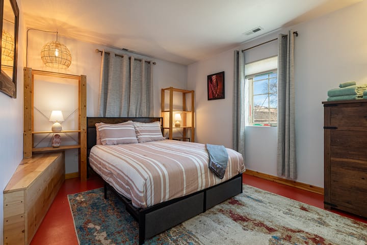 Dormitorio en la planta baja (abajo) también conocido como "habitación Canyon", con cama tamaño queen. Junto a la planta baja baño completo con bañera de hidromasaje y lavandería.