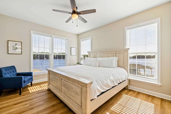 Bright and airy bedroom with a king-size bed, ceiling fan, and beautiful lake views