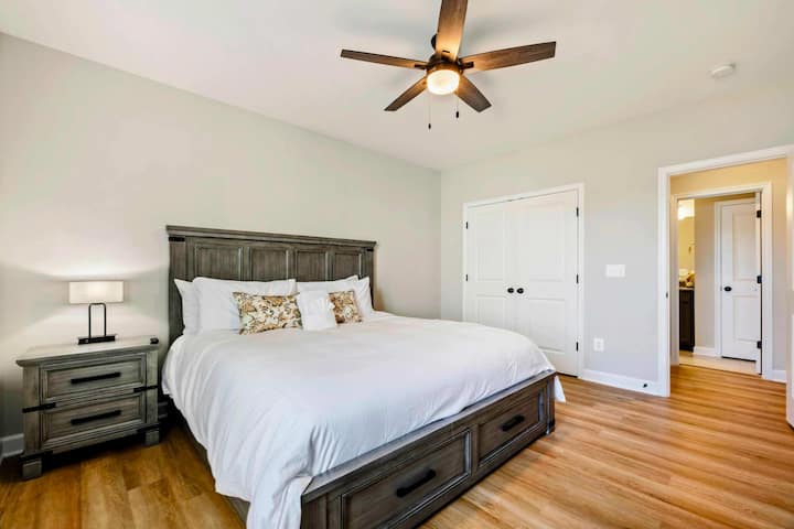 Elegant bedroom with a king-size bed, ceiling fan, and ample closet space