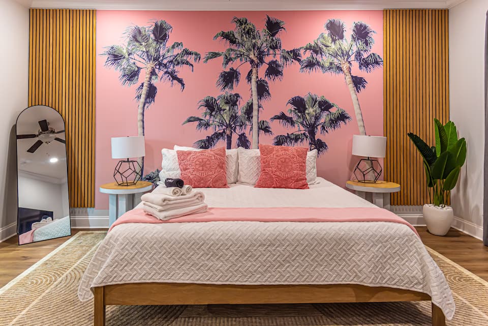 Primary suite with king bed and palm tree mural