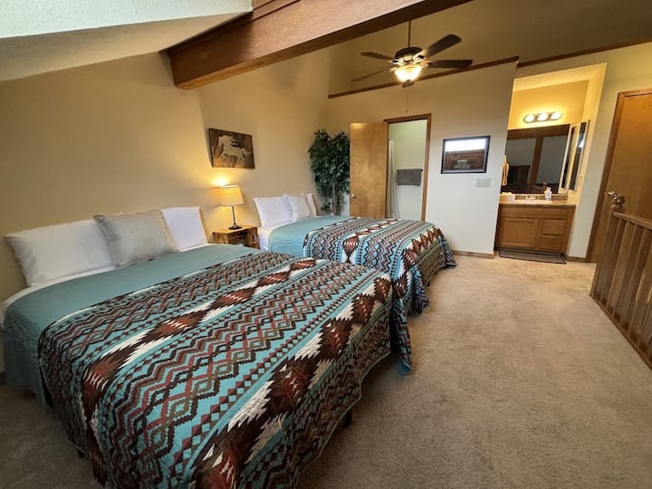 Two brand new comfortable queen beds in upstairs bedroom~ bedroom has no privacy walls and overlooks kitchen and living room on main level 