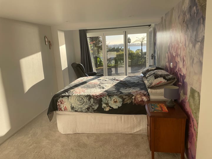 El dormitorio principal cuenta con una cama king, mesitas de noche con lámparas de lectura, un amplio espacio en el armario y vistas al agua.