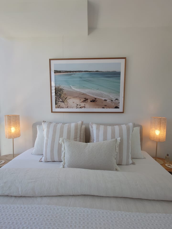A King sized bed with two side table and side lamps. Cotton sateen bedsheets with French flax linen cover and Hilton Hotel Superior mattress topper for a "cloud-like sleep"