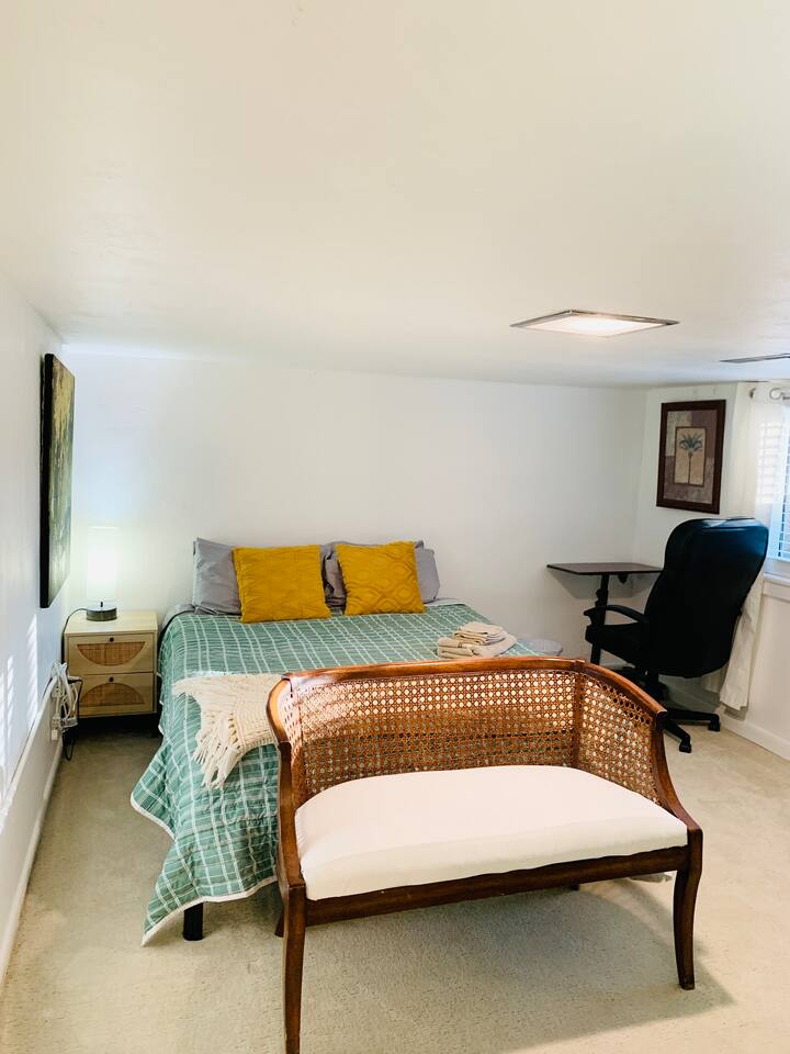 Dormitorio con cama tamaño queen y mesa de trabajo