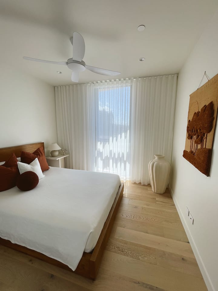 Ukiwa na mwonekano wa ufukweni, chumba cha kulala cha pili kina Kitanda cha Malkia kilicho na mashuka laini ya buttery na vifaa vya asili vilivyo na vazi lililojengwa ndani.