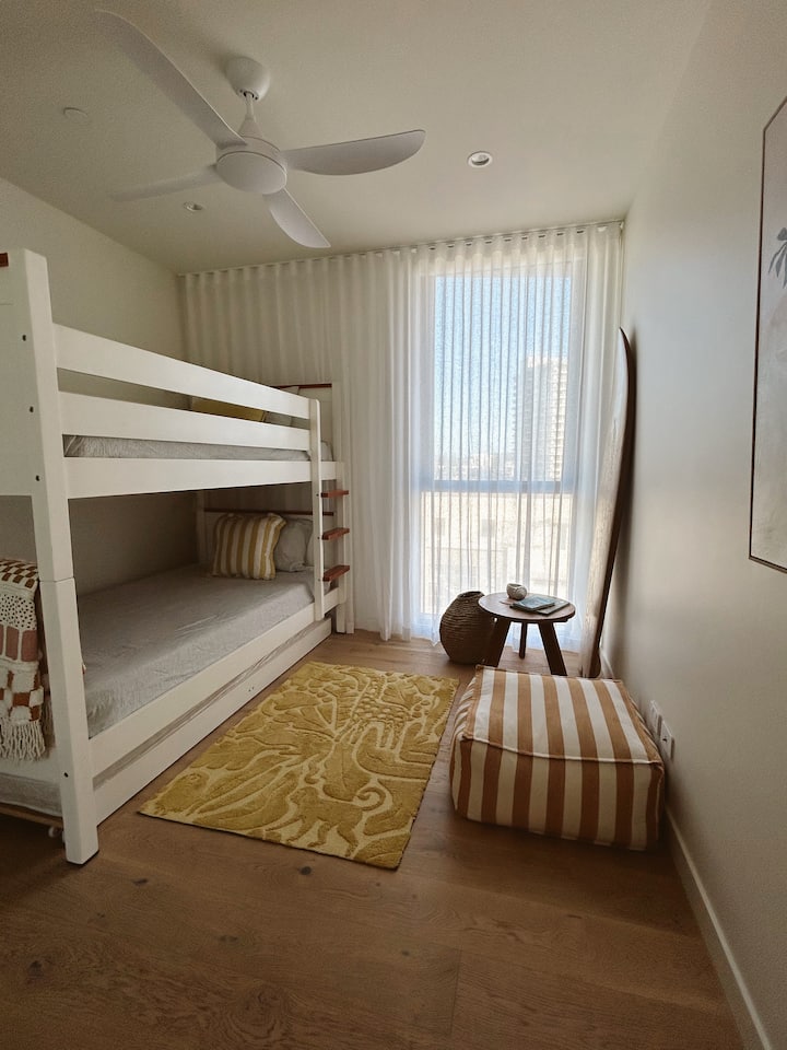 Mionekano ya ufukweni kutoka vitandani, chumba cha kulala cha tatu kina kitanda cha ghorofa cha King Single mara tatu (trundle ya tatu inaweza kutengenezwa kama inavyohitajika) na mashuka laini ya buttery na mapambo ya kipekee.