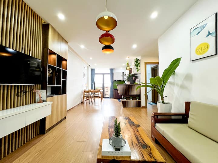 סלון מואר ונעים עם אור טבעי, ריהוט מעץ בהיר ופריסה פתוחה - מושלם למשפחות ליד חוף מיי קה.