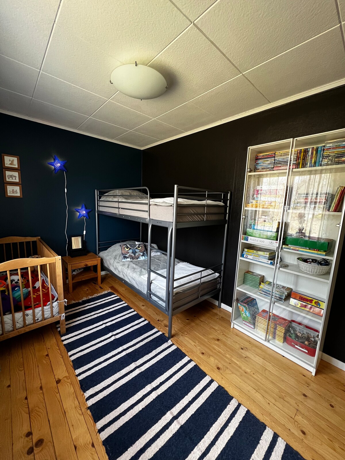 Საძინებელი ზემოთ მდებარე საწოლით, საწოლით და დამატებითი საწოლით. 