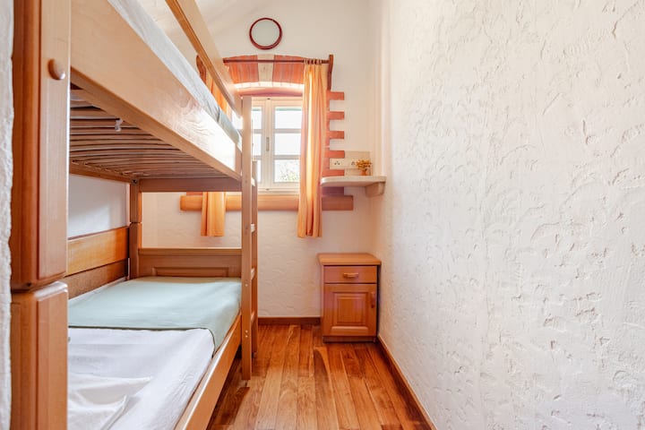 The second bedroom in the main house features comfortable bunk beds. It is a cozy space, absolutely perfect for kids or friends, offering a fun and practical setup for your stay.